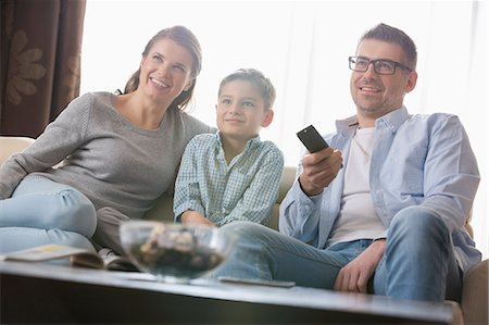 dad watching tv - Boy watching TV with parents in living room Stock Photo - Premium Royalty-Free, Code: 693-07673259