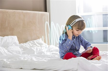 simsearch:693-07542254,k - Full length of boy listening music through headphones on bed Stock Photo - Premium Royalty-Free, Code: 693-07673304