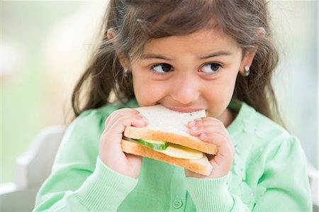 Little girl eating sandwich at home Foto de stock - Sin royalties Premium, Código: 693-07912146