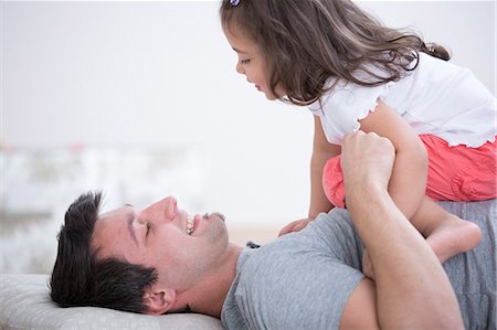 Side view of playful father and daughter at home Foto de stock - Sin royalties Premium, Código: 693-07912148