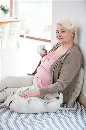 dog living in a house - Portrait of happy senior woman having coffee while stroking dog at home Stock Photo - Premium Royalty-Free, Code: 693-07912151