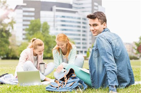simsearch:693-07912254,k - Portrait of young man with female friends studying on university campus Foto de stock - Sin royalties Premium, Código: 693-07912210