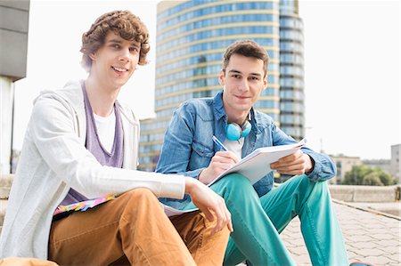 simsearch:693-07912221,k - Portrait of young male college students studying on steps against building Foto de stock - Sin royalties Premium, Código: 693-07912247