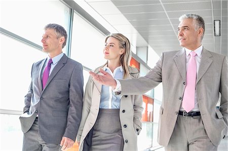 Businesspeople communicating while walking on train platform Stock Photo - Premium Royalty-Free, Code: 693-07912292