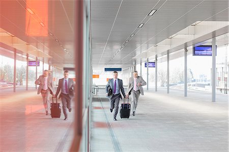 Full length of businessmen with luggage rushing on railroad platform Photographie de stock - Premium Libres de Droits, Code: 693-07912306