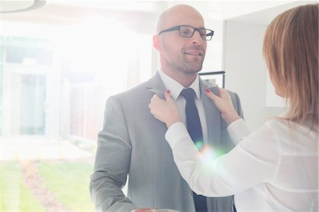 Woman dressing up businessman at home Stock Photo - Premium Royalty-Free, Code: 693-07912357