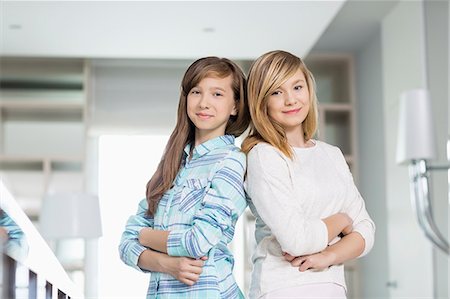 Portrait of cute sisters standing together at home Stock Photo - Premium Royalty-Free, Code: 693-07912380