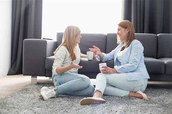Happy mother and daughter talking while having coffee in living room Photographie de stock - Premium Libres de Droits, Le code de l’image : 693-07912405