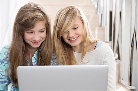 simsearch:693-07673213,k - Sisters using laptop on stairway Stock Photo - Premium Royalty-Free, Code: 693-07912418