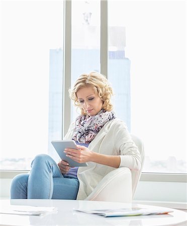 sitting cross legged - Beautiful businesswoman using tablet PC at creative office lobby Stock Photo - Premium Royalty-Free, Code: 693-07912551