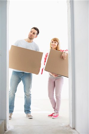 simsearch:693-07912642,k - Full-length of couple with cardboard boxes standing in front of entrance Photographie de stock - Premium Libres de Droits, Code: 693-07912565