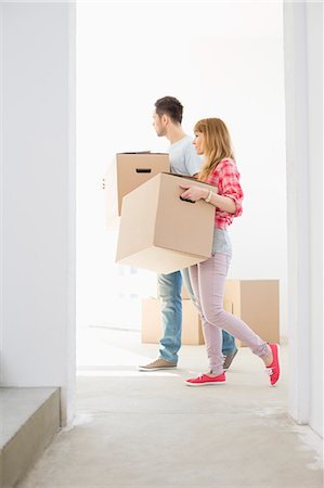 simsearch:693-07912642,k - Full-length side view of couple walking with cardboard boxes Photographie de stock - Premium Libres de Droits, Code: 693-07912566