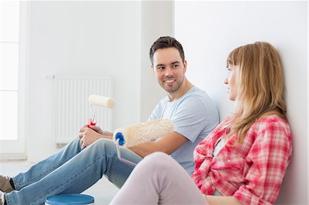 Couple taking break from painting in new home Stock Photo - Premium Royalty-Free, Code: 693-07912574