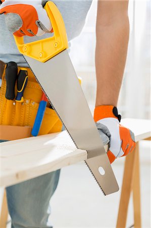 diy - Midsection of man sawing wood in new house Foto de stock - Sin royalties Premium, Código: 693-07912596