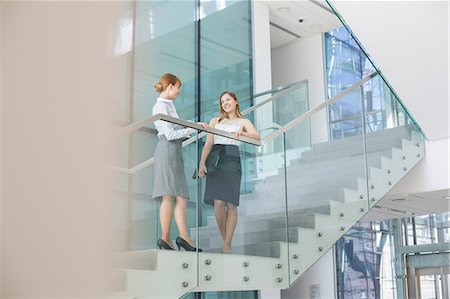simsearch:693-07912682,k - Businesswomen conversing on steps in office Foto de stock - Sin royalties Premium, Código: 693-07912693
