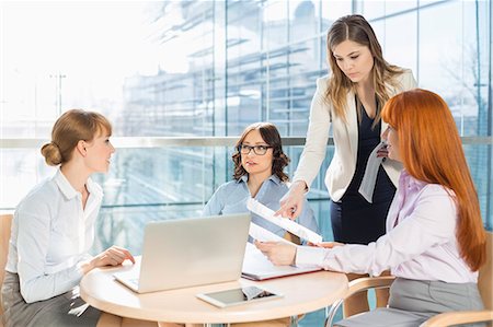 simsearch:6108-05868100,k - Businesswomen discussing over documents at table in office Stock Photo - Premium Royalty-Free, Code: 693-07912704