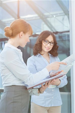 simsearch:693-07912729,k - Businesswoman showing document to colleague in office Stock Photo - Premium Royalty-Free, Code: 693-07912745