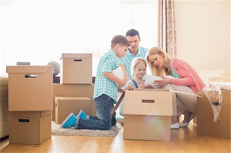 Family unpacking cardboard boxes at new home Stock Photo - Premium Royalty-Free, Code: 693-07912757