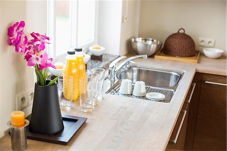 europe windows flowers - Flower vase with juice bottles on kitchen counter Stock Photo - Premium Royalty-Free, Code: 693-07912777