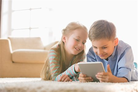 europe preteens - Brother and sister using digital tablet on floor at home Stock Photo - Premium Royalty-Free, Code: 693-07912811