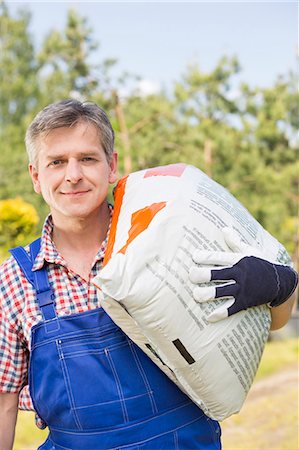 simsearch:693-07912856,k - Portrait of confident gardener carrying sack in plant nursery Stock Photo - Premium Royalty-Free, Code: 693-07912851
