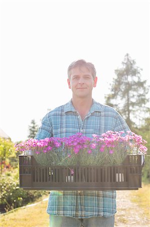 simsearch:693-07912856,k - Portrait of man carrying crate with flower pots in garden Stock Photo - Premium Royalty-Free, Code: 693-07912876