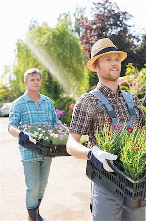 simsearch:693-07912856,k - Gardeners carrying flower pots in crates at plant nursery Stock Photo - Premium Royalty-Free, Code: 693-07912870