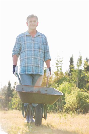 simsearch:693-07912855,k - Portrait of male gardener pushing wheelbarrow at garden Stock Photo - Premium Royalty-Free, Code: 693-07912885
