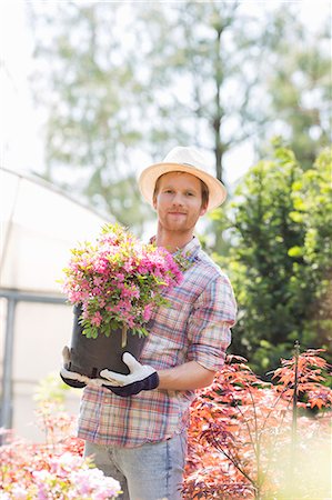 simsearch:693-07912856,k - Portrait of gardener holding flower pot outside greenhouse Stock Photo - Premium Royalty-Free, Code: 693-07912894
