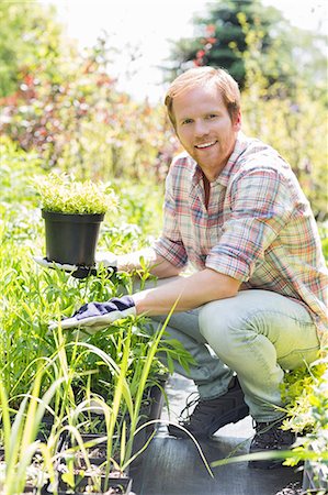 simsearch:693-07912856,k - Full-length portrait of happy man holding potted plant at garden Stock Photo - Premium Royalty-Free, Code: 693-07912890