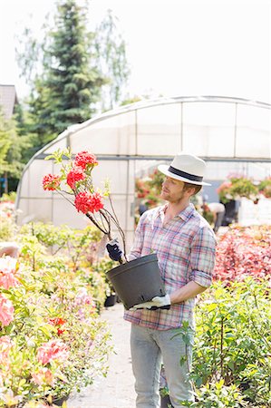 simsearch:693-07912926,k - Male gardener looking at flower pot outside greenhouse Foto de stock - Sin royalties Premium, Código: 693-07912901