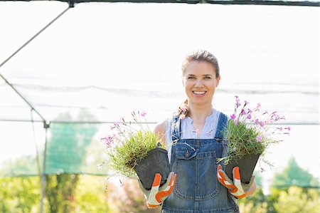 simsearch:693-06121284,k - Portrait of confident gardener holding potted plants at greenhouse Stock Photo - Premium Royalty-Free, Code: 693-07912919