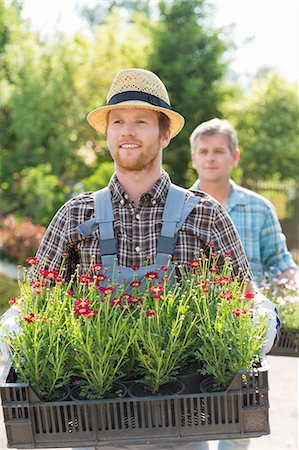 simsearch:693-07912855,k - Male gardeners carrying flower pots in crates at plant nursery Stock Photo - Premium Royalty-Free, Code: 693-07912934