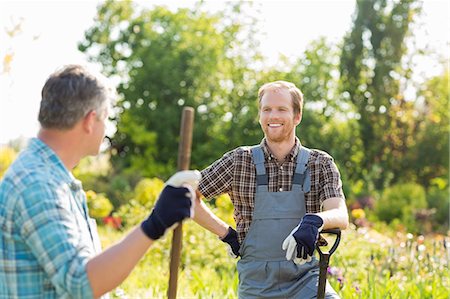 Happy gardeners talking at plant nursery Stock Photo - Premium Royalty-Free, Code: 693-07912939