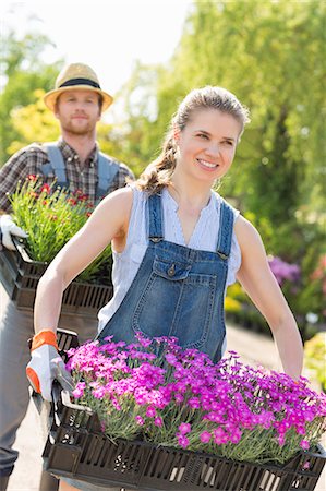 simsearch:693-07912855,k - Smiling gardeners carrying flower pots in crates at plant nursery Stock Photo - Premium Royalty-Free, Code: 693-07912931