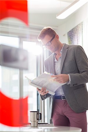 simsearch:400-04082460,k - Businessman reading file in creative office Stock Photo - Premium Royalty-Free, Code: 693-07912941