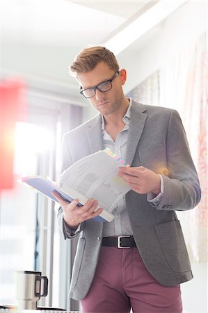 simsearch:400-04082460,k - Businessman reading documents in creative office Stock Photo - Premium Royalty-Free, Code: 693-07912942