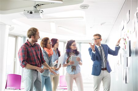 documento - Creative businessman giving presentation to colleagues in office Foto de stock - Sin royalties Premium, Código: 693-07913008