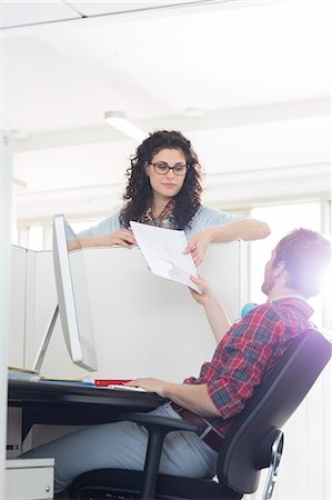 simsearch:693-07912462,k - Businessman handing over document to female colleague over cubicle wall Stock Photo - Premium Royalty-Free, Code: 693-07913033