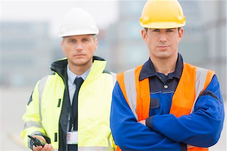 simsearch:693-07913158,k - Portrait of confident worker standing with coworker in shipping yard Stock Photo - Premium Royalty-Free, Code: 693-07913072