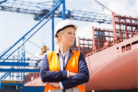 engineer standing with arms crossed - Confident female engineer in shipping yard Photographie de stock - Premium Libres de Droits, Code: 693-07913101