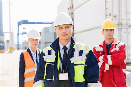 engineer standing with arms crossed - Confident workers standing in shipping yard Photographie de stock - Premium Libres de Droits, Code: 693-07913130