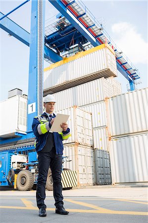 simsearch:693-07913158,k - Full-length of male supervisor writing on clipboard in shipping yard Stock Photo - Premium Royalty-Free, Code: 693-07913150