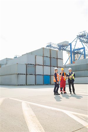 Full-length of workers talking in shipping yard Fotografie stock - Premium Royalty-Free, Codice: 693-07913167