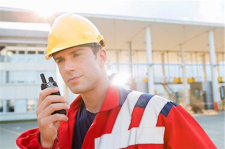 simsearch:649-08118285,k - Male worker using walkie-talkie in shipping yard Photographie de stock - Premium Libres de Droits, Code: 693-07913169