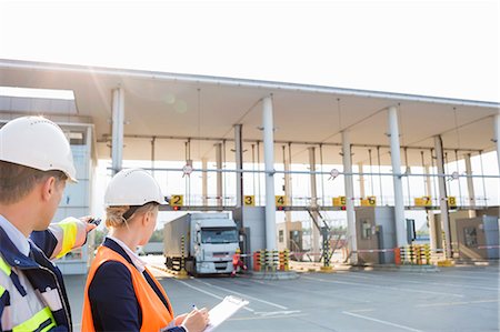 employee hold a sign - Supervisors looking at truck entering in shipping yard Stock Photo - Premium Royalty-Free, Code: 693-07913177