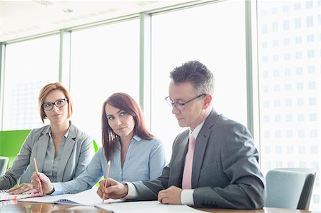 simsearch:693-07913191,k - Business people writing on books at conference table Stock Photo - Premium Royalty-Free, Code: 693-07913270