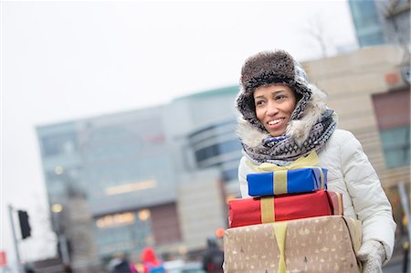 Happy woman looking away while carrying stacked gifts during winter Stock Photo - Premium Royalty-Free, Code: 693-08126888