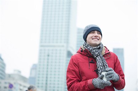 simsearch:693-08127426,k - Happy man in warm clothing holding disposable cup outdoors Stock Photo - Premium Royalty-Free, Code: 693-08126893