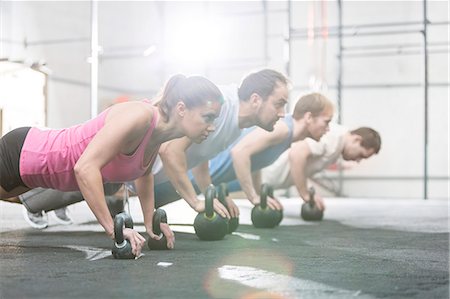 ropa deportiva - Side view of determined people doing pushups with kettlebells at crossfit gym Foto de stock - Sin royalties Premium, Código: 693-08126972